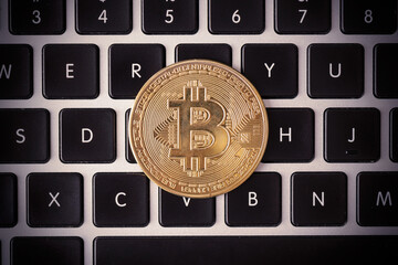 Golden coins with bitcoin symbol on keyboard