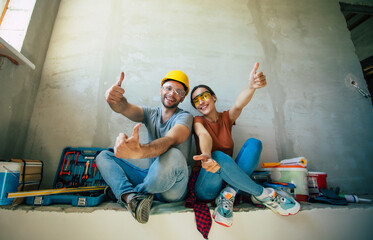 Modern happy young couple in love in casual clothes during new home repair or renovation of walls...