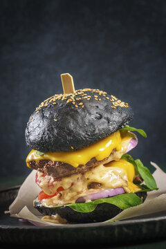 Double beef patty burger with a black bun on dark background