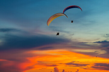 Skydiving sunset landscape of parachutist flying in soft focus. Para-motor flying silhouette with...