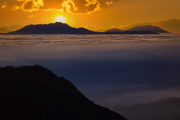 The morning sun and the orange sky above the mountains. Twilight sky background. Colorful Sunset sky and cloud. vivid sky in twilight time background. Fiery orange sunset  Beautiful.