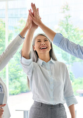 Cheerful happy coworkers asian businesswoman and male and female colleagues giving high five...