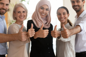 Happy multiethnic employees group with Asian muslim businesswoman team leader executive showing thumbs up close up, looking at camera, recommending corporate service, good career, human resources