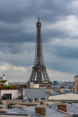 Paris, the Eiffel Tower, beautiful monument, and typical roofs, stormy weather
