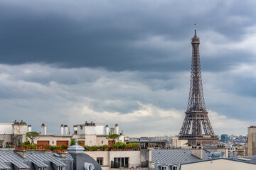 Paris, the Eiffel Tower, beautiful monument, and typical roofs, stormy weather

