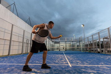 Young man with urban style trains paddle tennis on outdoor court