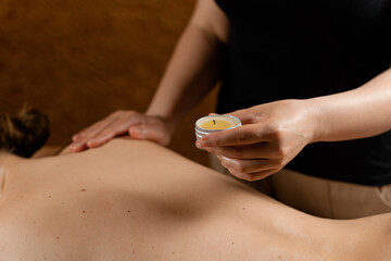 Obraz na płótnie Canvas Waxing body massage with candle. Beauty spa procedure. Thai massage with warm wax.