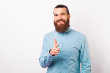 Portrait of handsome bearded man in casual pointing at the camera, point at you