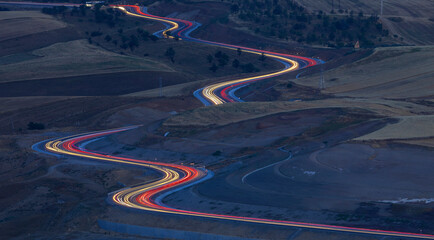 Traces from headlights of cars on a mountain pass in the evening