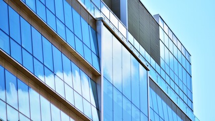 Obraz premium Abstract closeup of the glass-clad facade of a modern building covered in reflective plate glass. Architecture abstract background. Glass wall and facade detail.