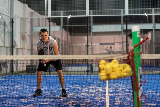 Paddle training of a young player with basket of balls - Powered by Adobe