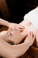 Fototapeta na wymiar Neck and face massage in the spa. Beauty treatments for an attractive female model. Relaxation,