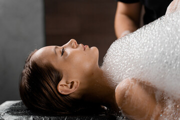 Close-up foam peeling massage for model in spa. Relaxation in Turkish hammam - obrazy, fototapety, plakaty
