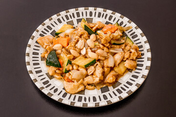 Usual Chinese restaurant recipe of chicken with almonds and vegetables sautéed with soy sauce on a plate engraved