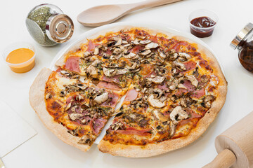 Pizza with mushrooms, ham, oregano, made with thin dough