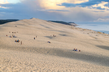 The Great Dune of Pyla (or Pilat) before sunset. People climbing the dune.  Arcachon Bay, France.