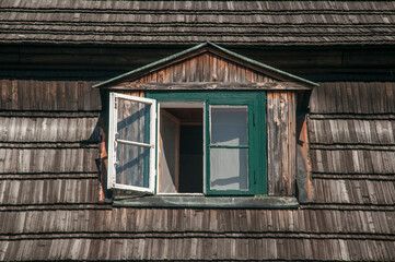 otwarte okno na poddaszu drewnianego domu
