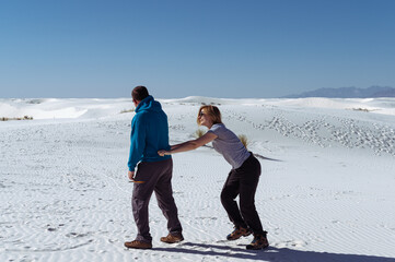 Vertical photo of a flirting couple in the desert of White Sands National Park, NM, USA