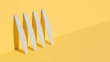 Set of nail files, emery board for nails of different shapes and different stiffness on a yellow background. isometric diagonal projection.Minimal, Trendy shadows, Modern photo.Mock up for manicurist