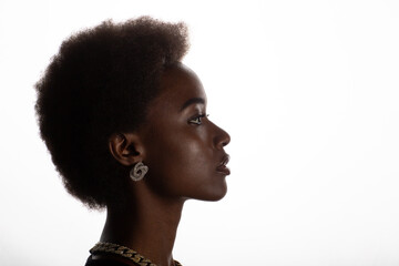 Close up profile portrait of black african american woman with afro hairstyle on white studio background.