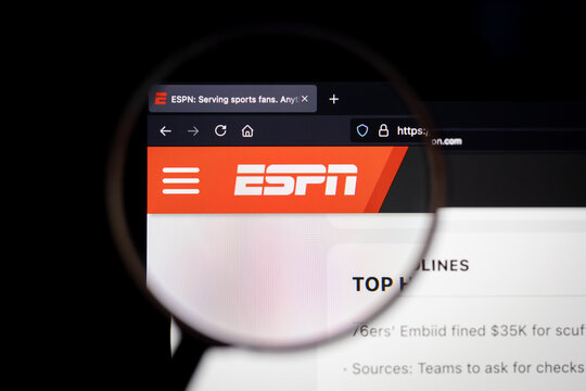 ESPN company logo on a website  seen on a computer screen through a magnifying glass.