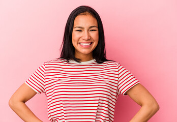 Fototapeta premium Young Venezuelan woman isolated on pink background confident keeping hands on hips.