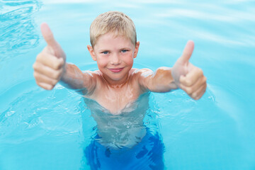 Fototapeta na wymiar Little funny boy in the swimming pool