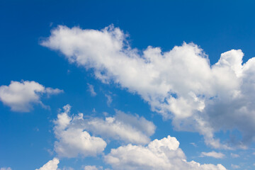Naklejka na ściany i meble Blue sky with white and gray clouds. Bright sunny cloudscape 