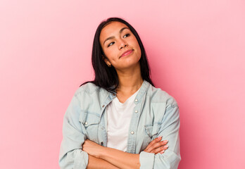 Young Venezuelan woman isolated on pink background dreaming of achieving goals and purposes