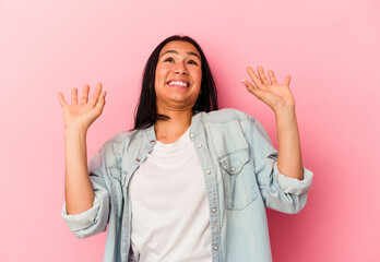 Young Venezuelan woman isolated on pink background screaming to the sky, looking up, frustrated.