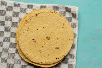 Mexican corn tortillas on turquoise background