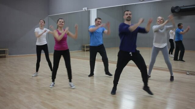 Cheerful people practicing vigorous lindy hop movements in dance class. High quality FullHD footage