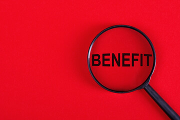 Magnifier with the word - BENEFIT, on a red background.