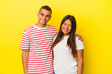 Fototapeta premium Young latin couple isolated on yellow background happy, smiling and cheerful.