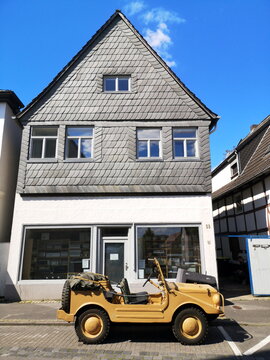 Alter DKW Munga Gel&auml;ndewagen der Sechzigerjahre in Khaki Lackierung f&uuml;r die W&uuml;ste vor einem Altbau mit Schieferfassade bei Sonnenschein am 30.05.2021 in Lemgo bei Detmold in Ostwestfalen-Lippe
