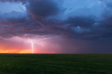 Lightning bolt strikes at dusk on the Wyoming / Colorado border with dark storm clouds overhead....