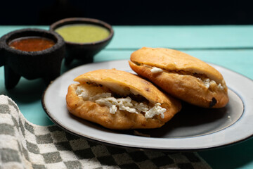 Chicharron gorditas with cheese on turquoise background. Mexican food