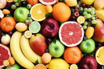 Fresh ripe organic fruits from market: apple and orange, grapefruit and banana, grape and berries