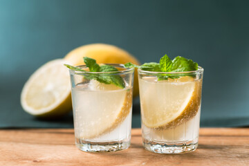 Cold Lemon soda in a glass on wooden with green background, Tropical and summer drink