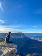 panoramic view of the Colorado River for their Grand Canyon during a few afternoon clouds. Boy sitting on a rock
