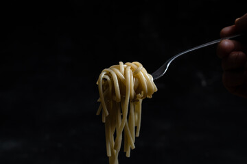 fork with noodles with black background