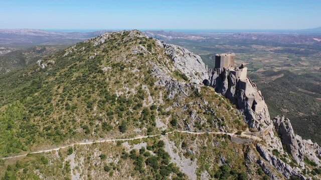Aerial view of stone ruins of ancient fortified Chateau de Queribus on rocky hilltop on sunny summer day, Aude departement, France