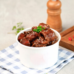 Selected Focus JJajang Tteokbokki and Odeng Korean Fish Cake on a WHite Cup for Takeaway. Jjang Topokki is Popular Korean Street Food with Traditional Korean Black Sauce