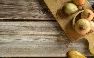 The onions on wood table for food or cooking concept.