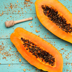 Papaya fruit half on turquoise background