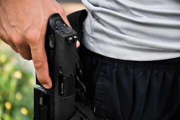 Automatic 9mm pistol holding in hand at the holster, it's ready to pull out and ready to shoot at...