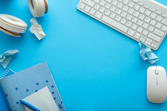 Frame with copy space made from office and school white blue stationery on pastel blue layout for work and education. Back to school concept. Blue desk workspace with mockup blank copy space