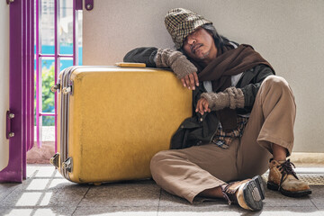 poor elderly homeless man sitting with luggage feel despair and lonely