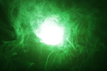 Fototapeta na wymiar Artificial magic smoke in green light on black background