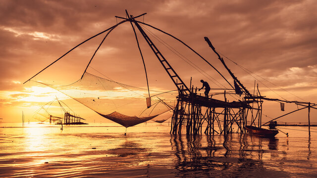 silhouette scenery of sunrise at pakpra phatthalung with thai traditional fishing trap
